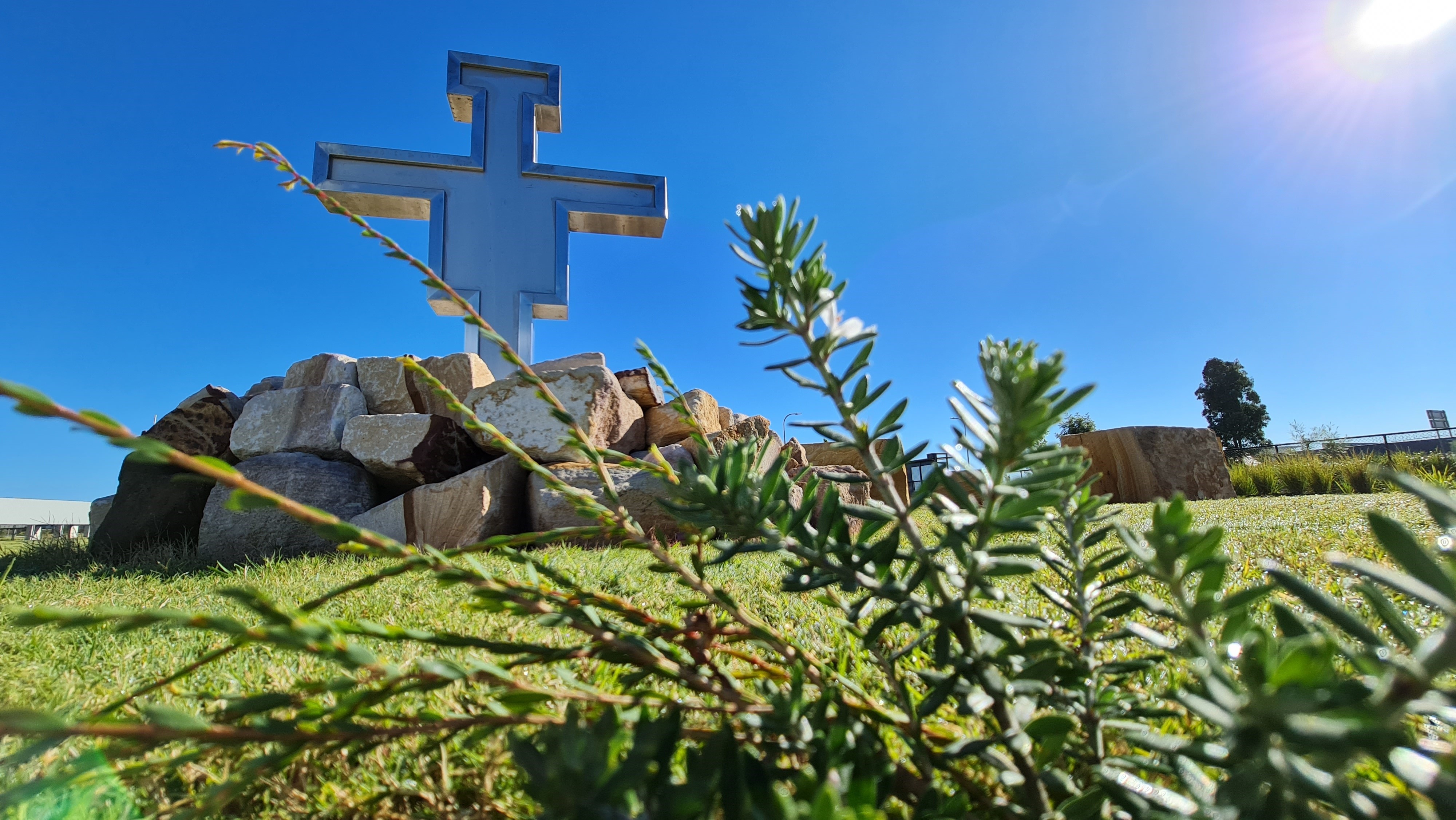 Decorative image of a crucifix on rocks outside.